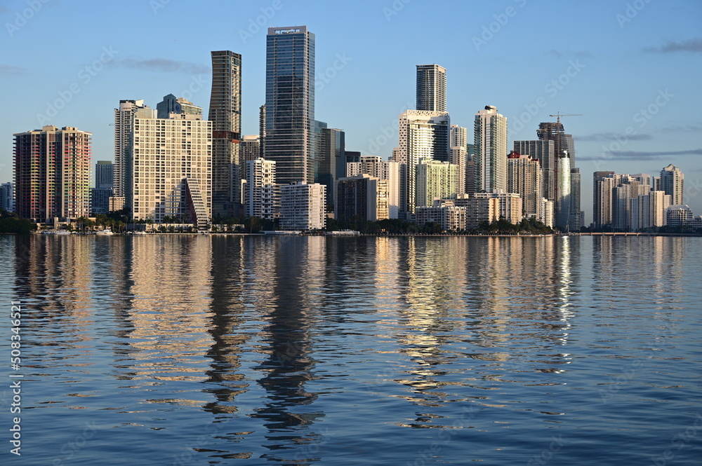Fototapeta premium Skyline of City of Miami, Florida reflected in calm water of Biscayne Bay on clear sunny morning.