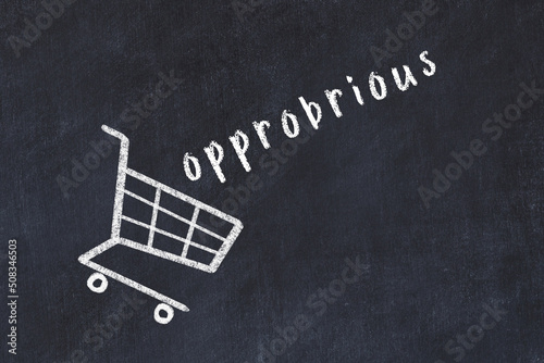 Chalk drawing of shopping cart and word opprobrious on black chalboard. Concept of globalization and mass consuming photo