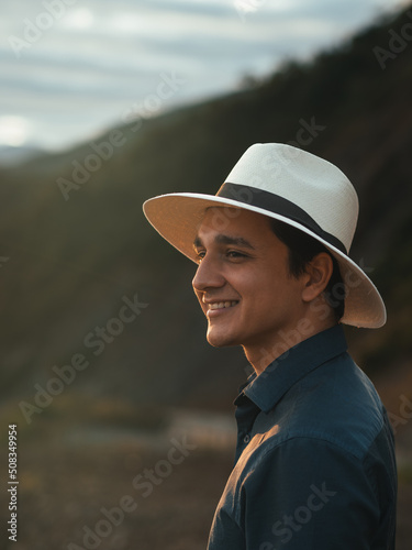 young man on vacation in the ecuadorian highlands smiles wearing his toquilla straw hat, the panama hat, made in Montecristi - ecuador photo