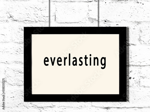 Black frame hanging on white brick wall with inscription everlasting