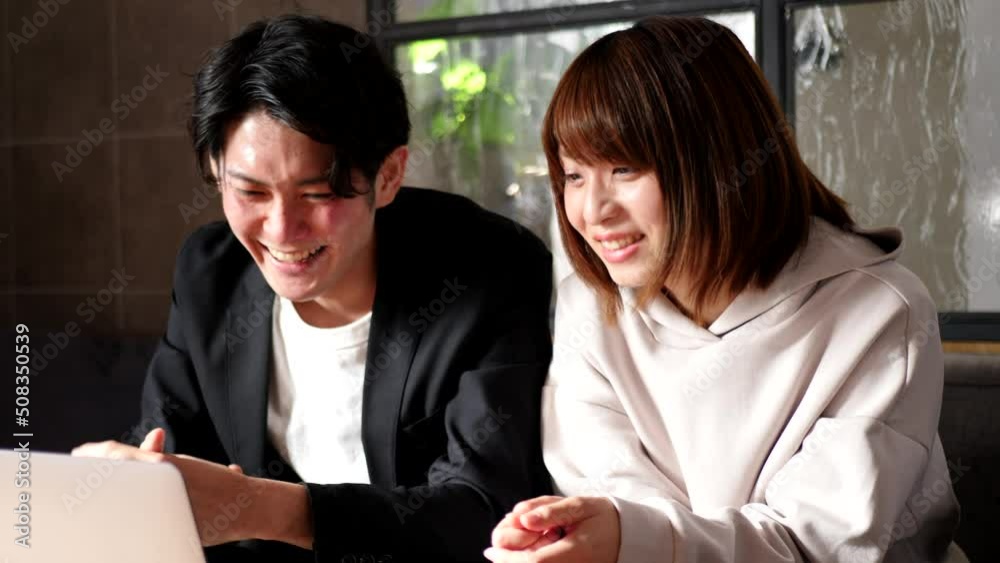 リビングのソファでくつろぐ若い日本人カップル リビングのソファでくつろぐ若い日本人カップル