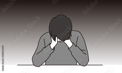 うつむき落ち込むアジア人男性