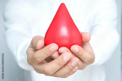 healthy man's hand holding blood symbol Blood Donation Help and Health Concepts