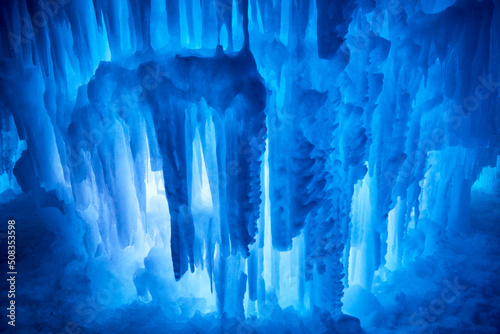 Beautiful gigantic icicles at night in winter forming a blue abstract art sculpture