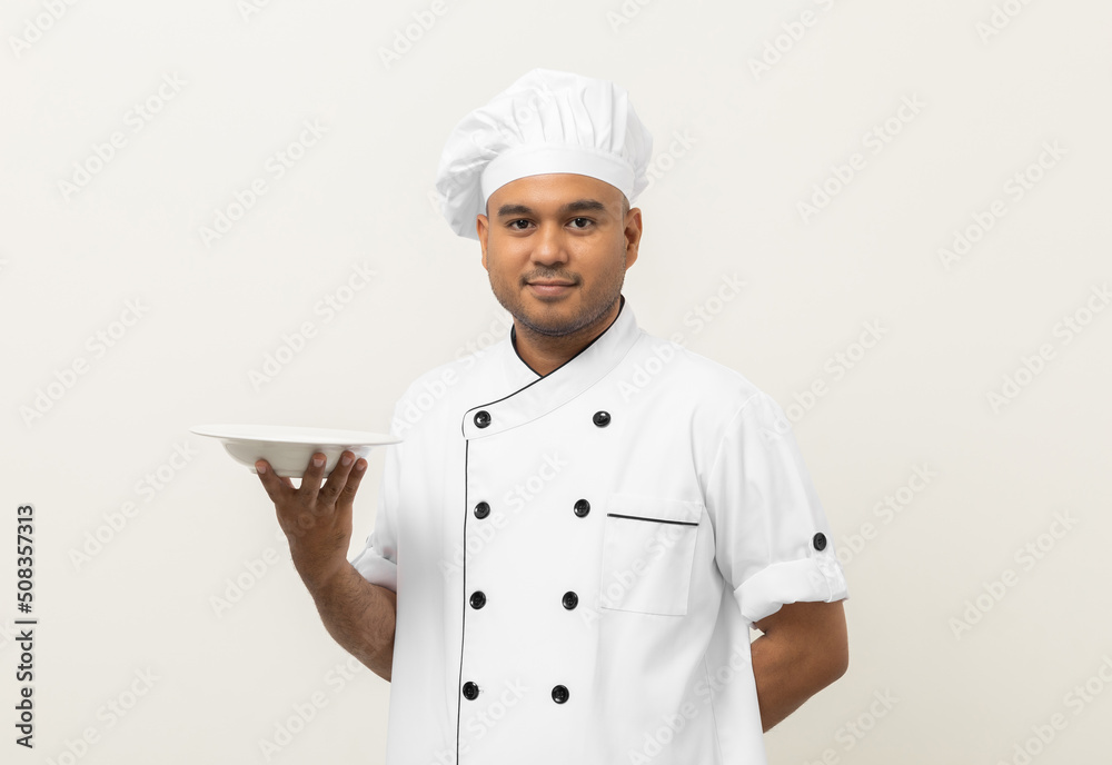 Attractive Young handsome asian man chef in uniform holding empty plate delicious dish menu good taste on isolated. Cooking indian man Occupation chef or baker People in kitchen restaurant and hotel. Attractive Young handsome asian man chef in uniform holding empty plate delicious dish menu good taste on isolated. Cooking indian man Occupation chef or baker People in kitchen restaurant and hotel.