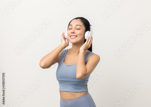 Sexy sporty fitness asian woman with sportswear put on headphone isolated white background. Portrait Good shape and healthy woman standing pose exercise workout in studio.