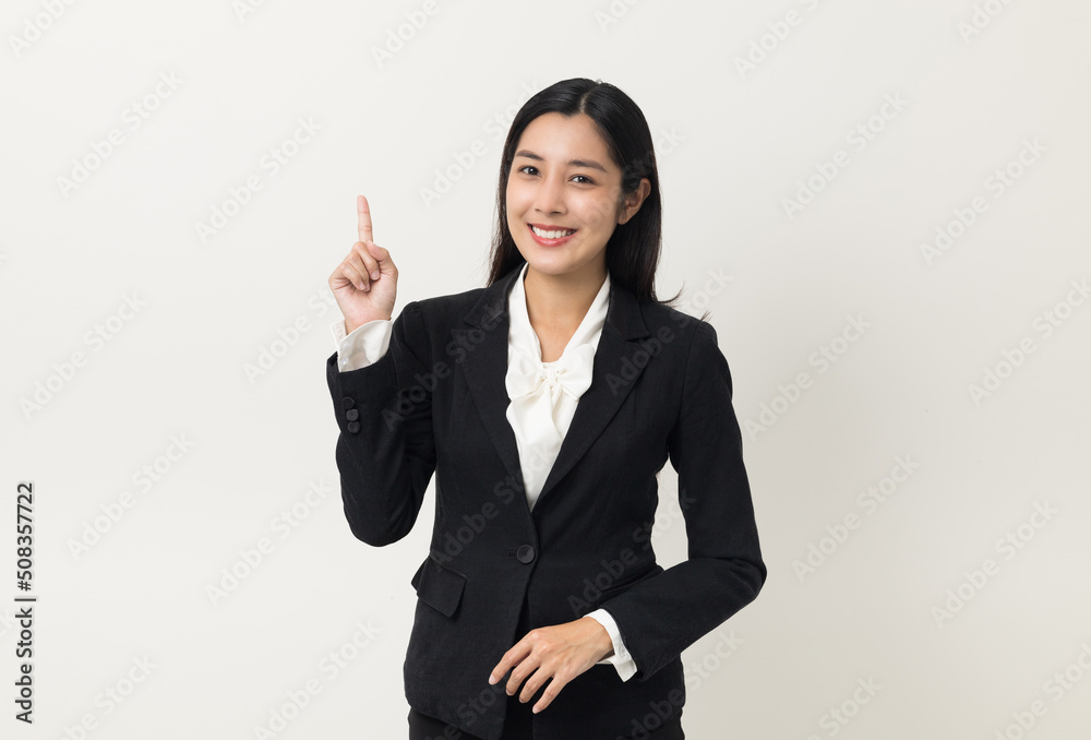 Young asian business woman smiling to camera standing pose on isolated white background. Female around 25 in suit portrait shot in studio. Young asian business woman smiling to camera standing pose on isolated white background. Female around 25 in suit portrait shot in studio.