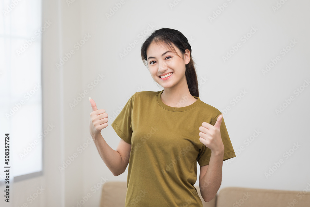 Young beautiful asian woman standing pose smiling to camera. Cheerfully sporty female workout and exercise wearing sport wear at home. Charming woman fitness training and stretching in living room Young beautiful asian woman standing pose smiling to camera. Cheerfully sporty female workout and exercise wearing sport wear at home. Charming woman fitness training and stretching in living room