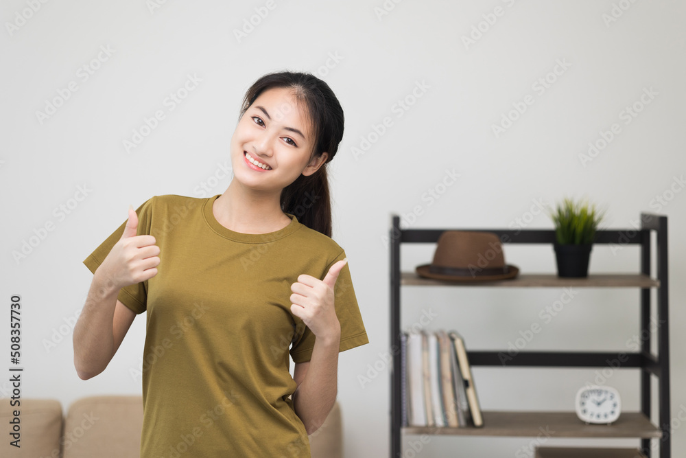 Young beautiful asian woman standing pose smiling to camera. Cheerfully sporty female workout and exercise wearing sport wear at home. Charming woman fitness training and stretching in living room Young beautiful asian woman standing pose smiling to camera. Cheerfully sporty female workout and exercise wearing sport wear at home. Charming woman fitness training and stretching in living room