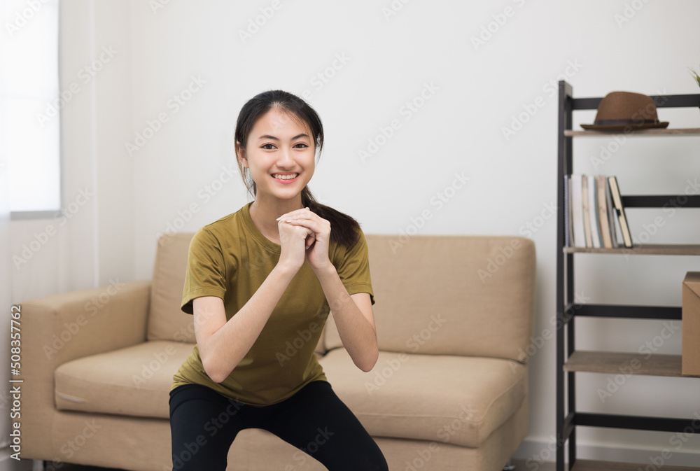 Young beautiful fitness asian woman doing squat sit up exercise workout at home. Attractive female warming up body training wearing sportswear. Side view Sporty girl stretching warm up cardio body. Young beautiful fitness asian woman doing squat sit up exercise workout at home. Attractive female warming up body training wearing sportswear. Side view Sporty girl stretching warm up cardio body.
