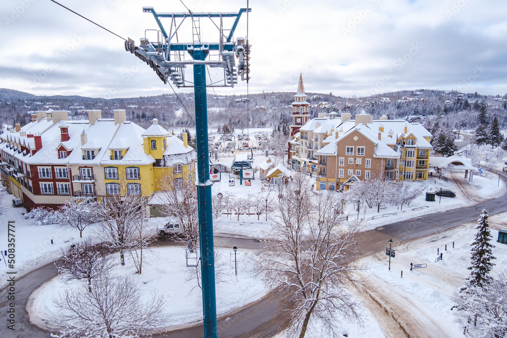 View on the Tremblant ski resort and the surrounding trees and ski resort on a snowy winter day from the Cabriolet, a small gondola in Tremblant village (Quebec, Canada)
