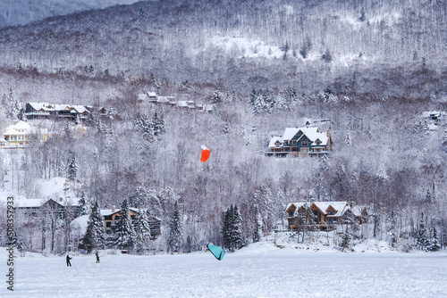 People snowkiting on a cold winter day on Lake Tremblant near Tremblant ski resort in Quebec (Canada) photo