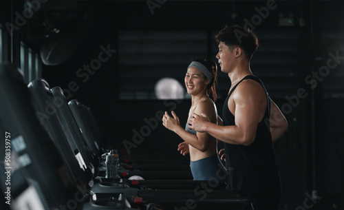 Asian beautiful sport woman wearing sportwear with workout headband under exercise on treadmill machine gym is sport healthy body building in fitness lifestyle. photo