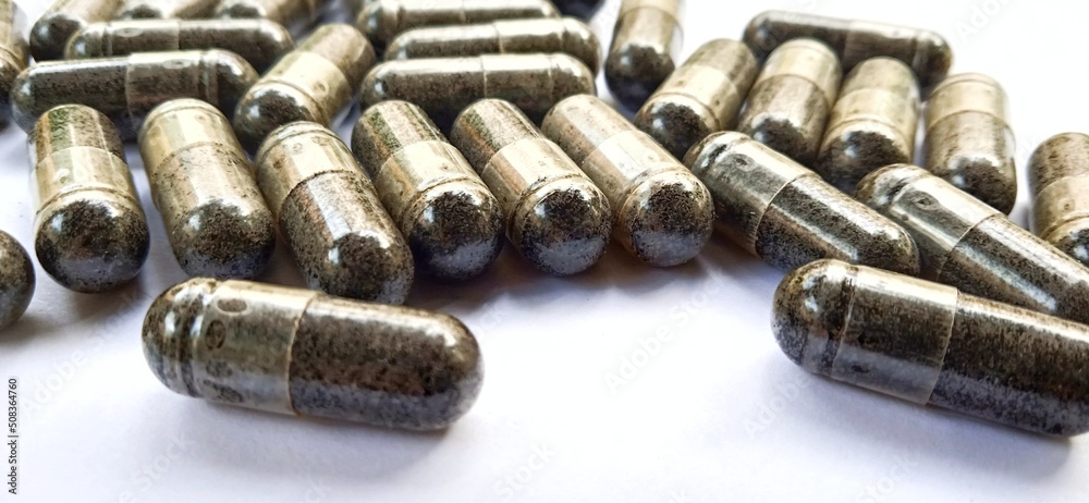 Herbal medicine black cumin capsules with negative space isolated on the gray white studio background. Nigella sativa. Suitable for promotion of health industry and company. Herbal medicine black cumin capsules with negative space isolated on the gray white studio background. Nigella sativa. Suitable for promotion of health industry and company.