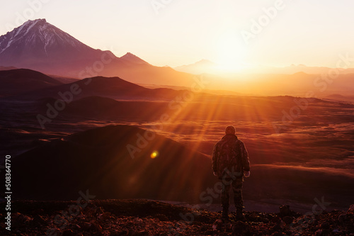 Foto Silhouette Male tourist meeting incredibly beautiful sunrise on mountain top wit
