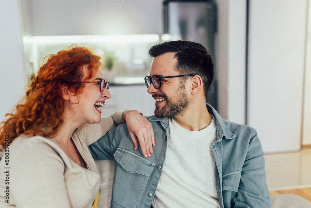 Young happy couple having fun while talking about something funny at home Young happy couple having fun while talking about something funny at home