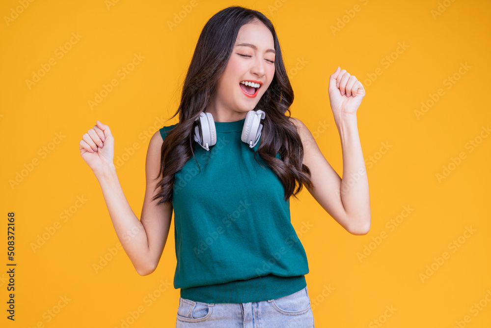 happiness carefree asian female woman teen wearing headphone listen dance joyful fun moving moment ,teen wear casaul cloth singing move while laugh smile trendy lifestyle studio shot