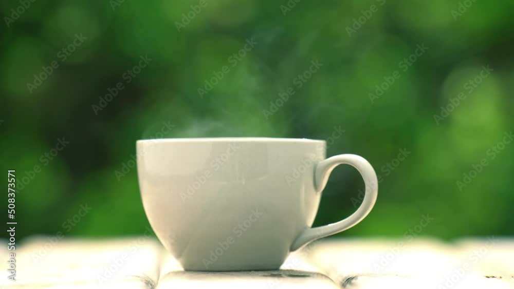 white ceramic coffee mug On the wooden floor, green tree bokeh background. white ceramic coffee mug On the wooden floor, green tree bokeh background.