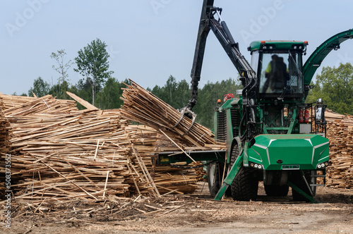 Heavy machine  hydraulic manipulator  in the process of working at a timber processing enterprise.