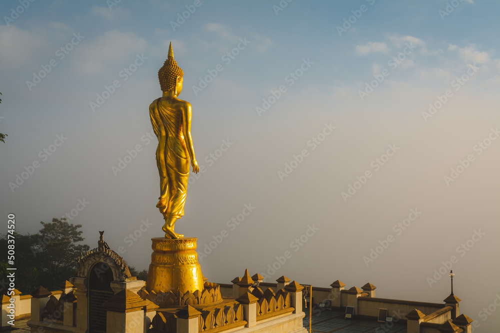 Golden Buddha statue in the morning at Wat Phra That Khao Noi, or Phrathat Khao Noi temple, is the top attraction with a fantastic view of Nan province, Thailand