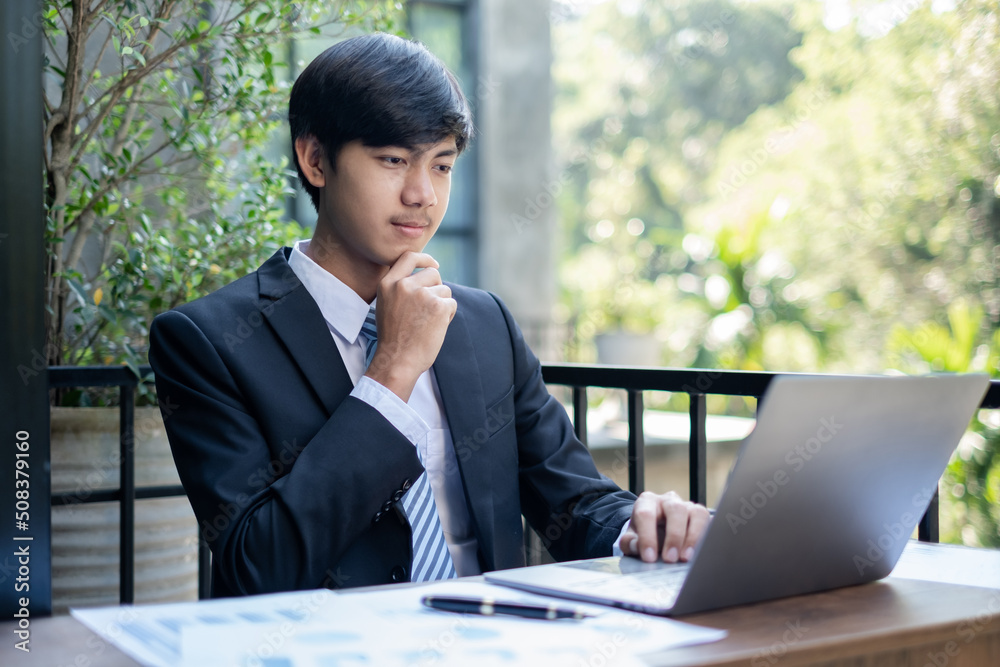 Young Asian businessman financial market analyst sits at their desks and calculate financial graphs showing the results of their investments planning the process of successful business growth Young Asian businessman financial market analyst sits at their desks and calculate financial graphs showing the results of their investments planning the process of successful business growth
