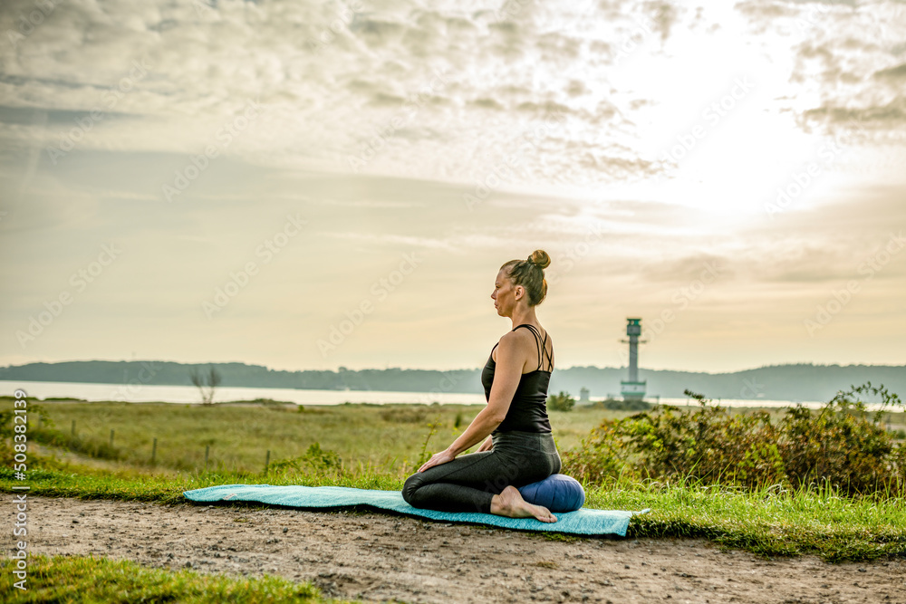 a woman is practicing yoga in the morning a woman is practicing yoga in the morning
