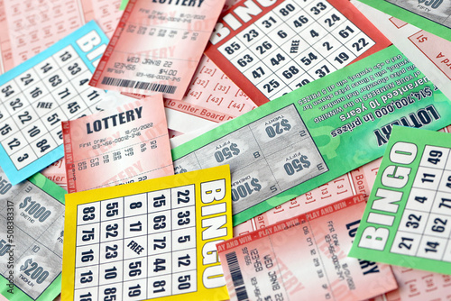 Many used lottery tickets, bills with numbers and bingo playing boards in big pile. Gambling and lottery paper stuff photo