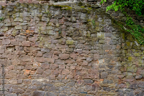 beautiful vintage texture of the wall of a medieval castle built in middle of 14th century, multi-colored volumetric stones for designer, wallpaper, rough sandy texture. Background for designer