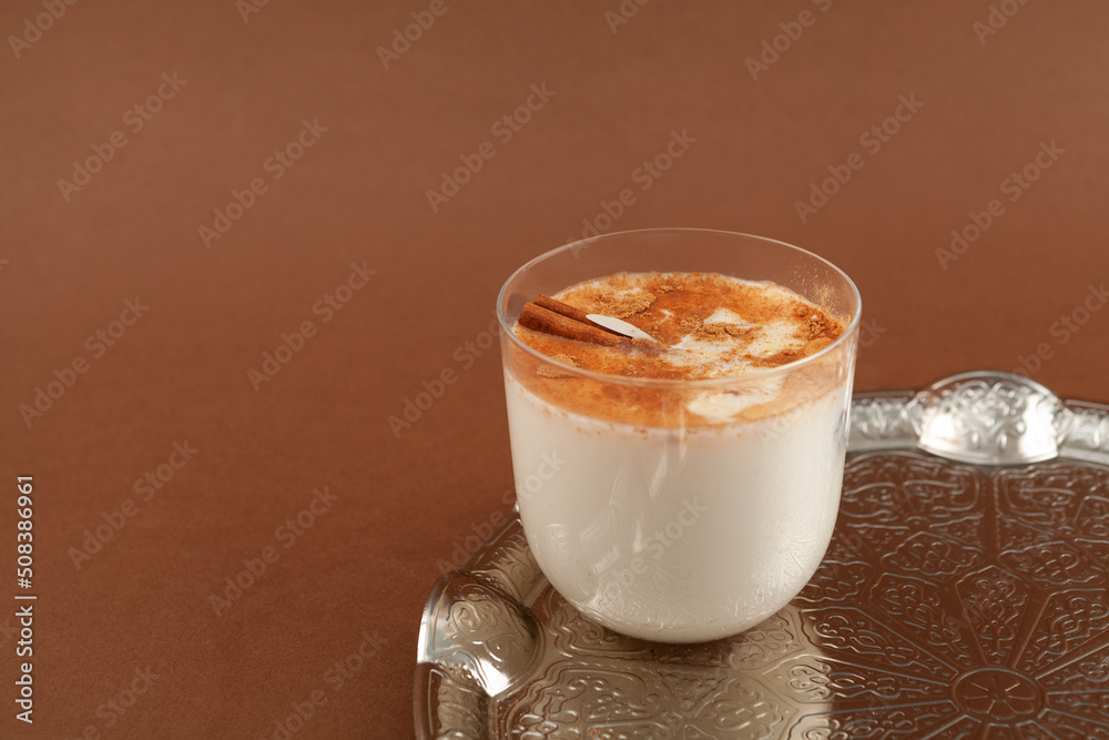 Salep or Sahlep in glass on brown background. Selective focus, copy space.  Salep - Turkish instantly drink with cinnamon Photos