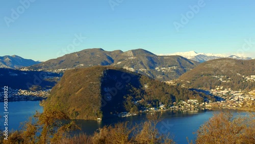 City of Lavena in Ponte Tresa and Caslano with Lake Lugano and Mountain View with Snow and Clear Blue Sky in a Sunny Day in Lombardy, Italy and Ticino, Switzerland. photo