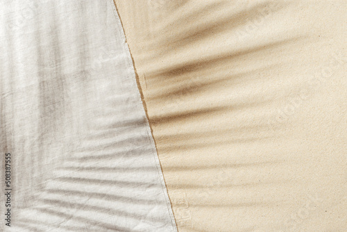 Billede på lærred Summer background, top view beach towel on sand with  sun shadow from palm leaf