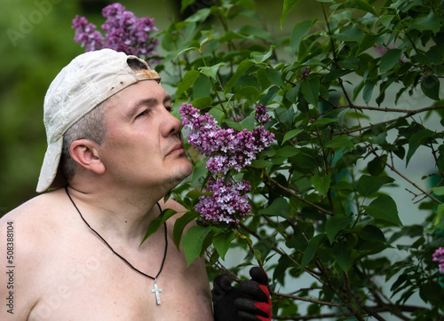 the guy in the cap sniffs lilac