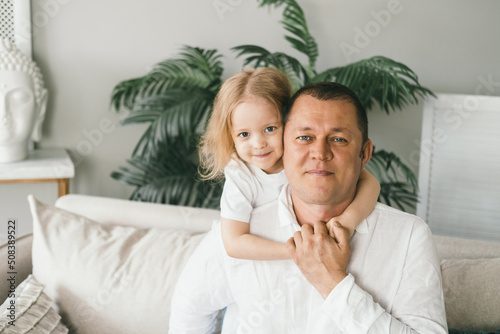 A little girl 4 years old gently hugs her dad.  © NS