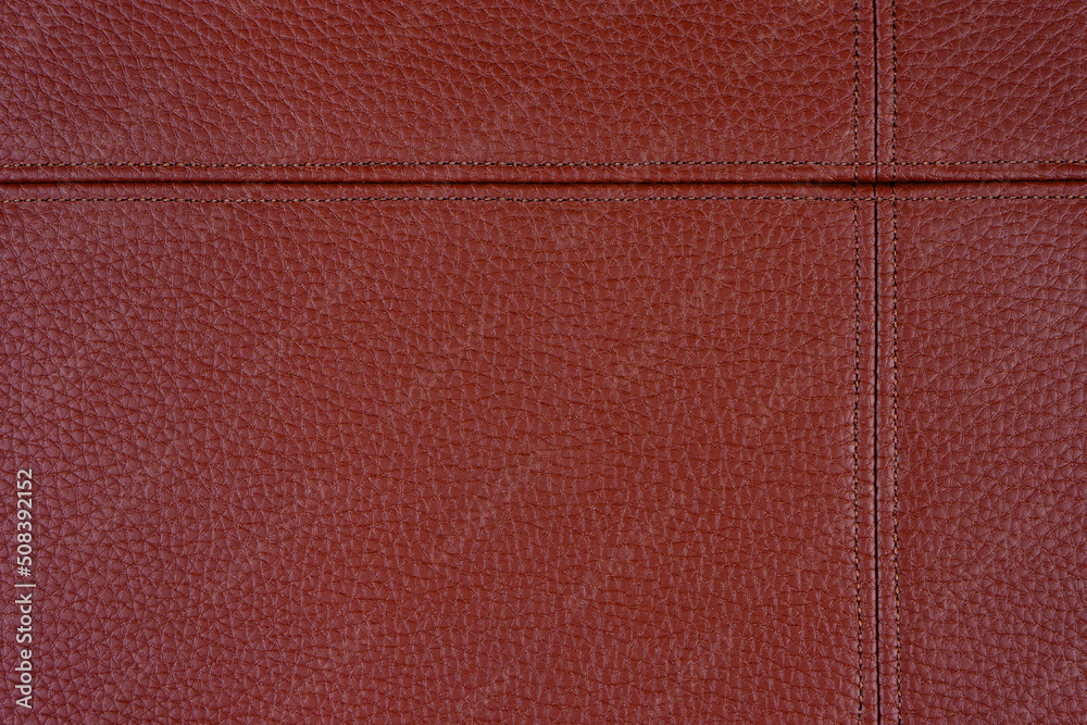 Fototapeta premium Natural, artificial red leather texture background with decorative seam. Material for sport items, clothes, furnitre and interior design. ecological friendly leatherette.