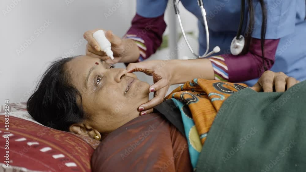 Nurse or doctor dripping eye drop to sleeping ill middle aged woman on bed - concept of therapy, treatment and medicare support