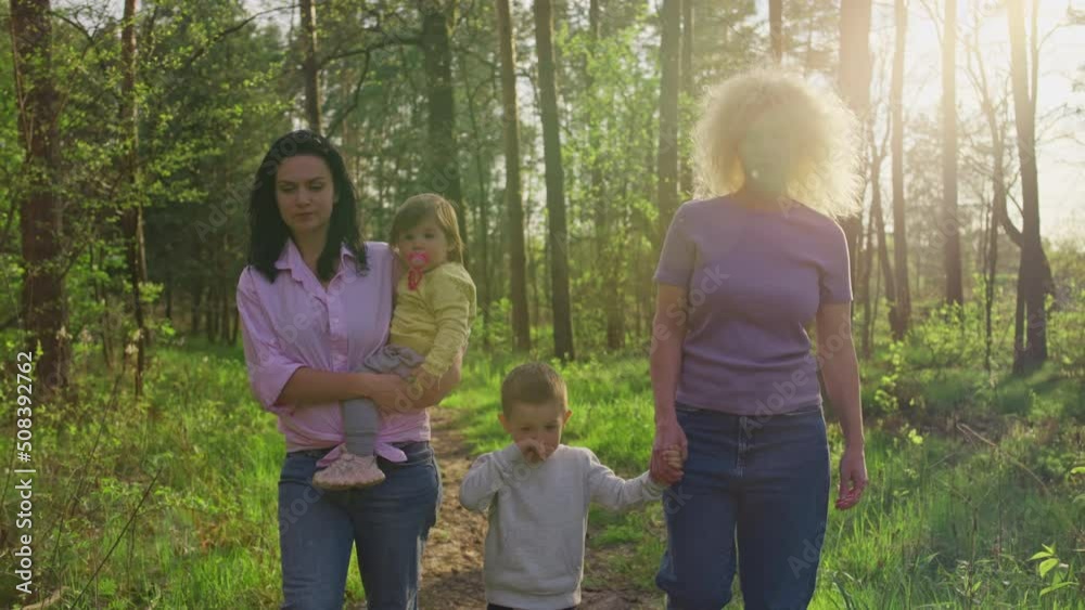 Grandmother mom and kids on a walk in the park. Happy together, family love of children to parents.
