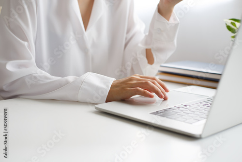 Woman s hand is moving a finger on touchpad on laptop to move cursor to the desired position.