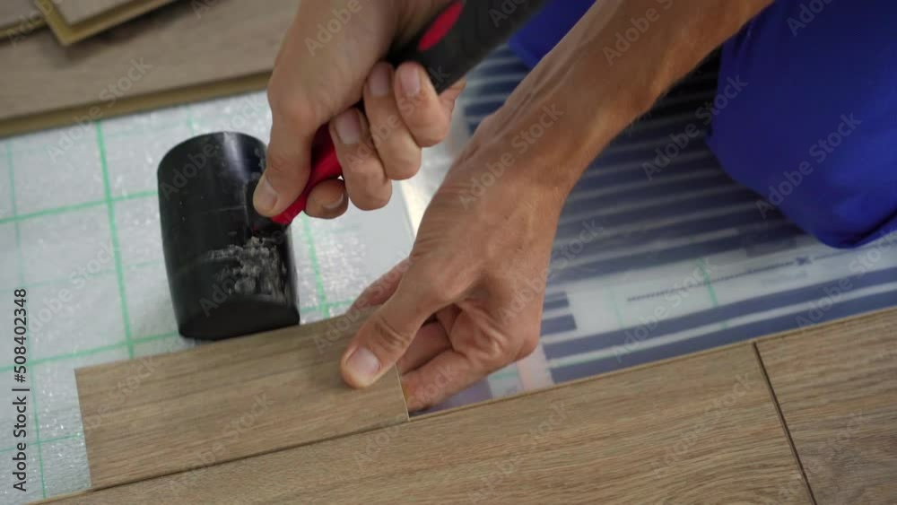 A man professional laminate installer laying laminate wood A man professional laminate installer laying laminate wood