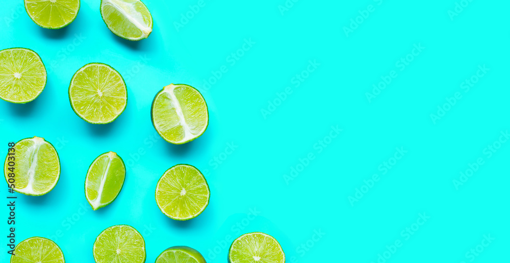 Fresh limes on blue background. top view
