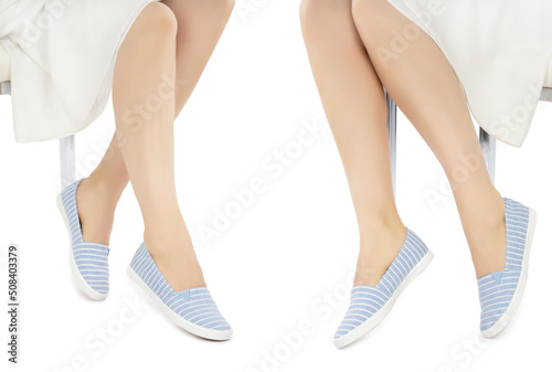 Legs in blue white striped and rhinestone moccasins on a white background. Front side view example showing shoes.