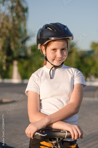 Girl 11 years old in the park with a bike. Children's sports and healthy lifestyle
