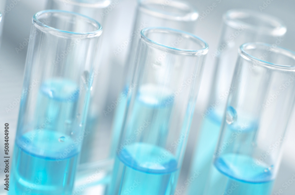 Laboratory test tubes with blue liquid close up, selective focus. Scientific laboratory research and experiments. Laboratory test tubes with blue liquid close up, selective focus. Scientific laboratory research and experiments.