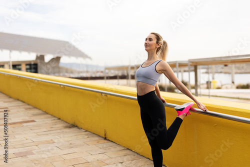 Beautiful young woman practising yoga outside. Fit woman doing yoga stretching exercises..