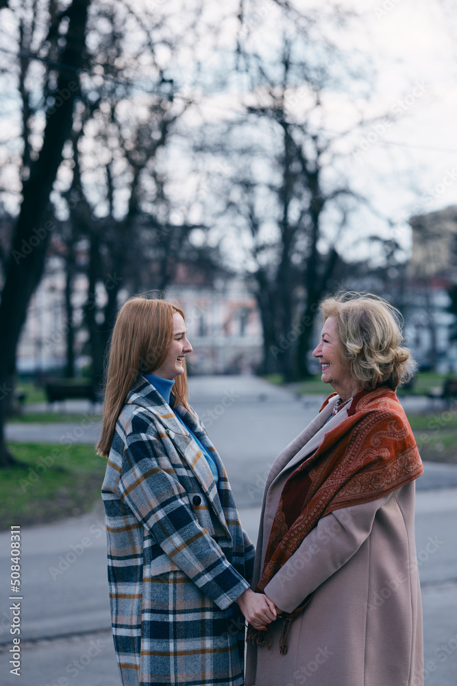 Fototapeta premium A happy grandmother and granddaughter hugs outside.
