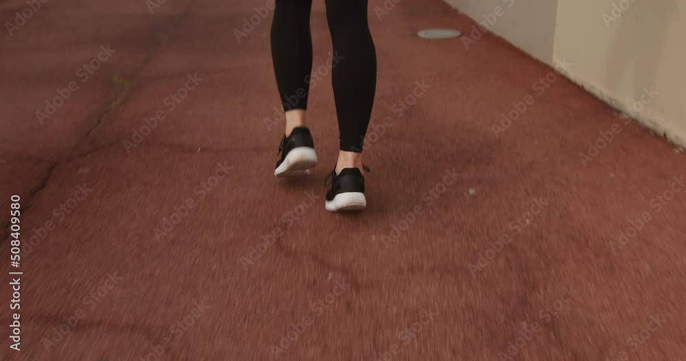Young fit woman running on red pavement while jogging Young fit woman running on red pavement while jogging
