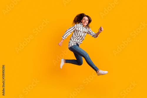 Full body profile side photo of young excited woman jump up active isolated over yellow color background