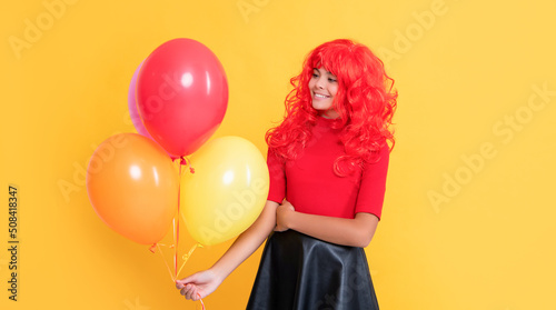 smiling teen girl with party balloon on yellow background