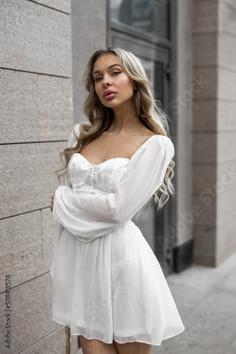 portrait of a beautiful young female with makeup in a white dress 