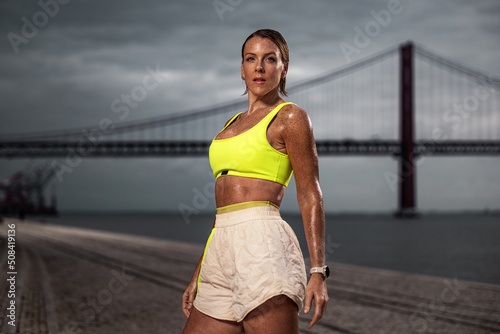 Woman in fitness wear doing workout outdoors.. Sporty gitl with fit body in sportswear posing on sky background. photo