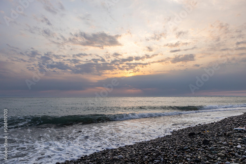 Adler Sochi Russia. View of a bright colorful sunset on the Black Sea coast on a pebble beach.